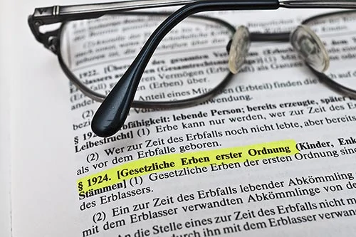 Deutscher Rechtstext zum Erbrecht mit hervorgehobenem Abschnitt Erbfolge; Gläserrest auf der Seite § 1924 Erbrecht. - Bestattungsunternehmen in Winsen, Harburg und in der Elbmarsch.