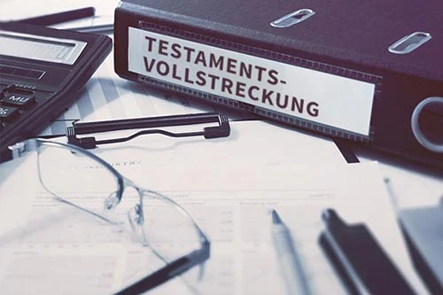 Ein Schreibtisch mit einem Ordner der Testamentsvollstreckung, Dokumenten, einer Brille und einem Taschenrechner. - Bestattungsunternehmen in Winsen, Harburg und in der Elbmarsch.